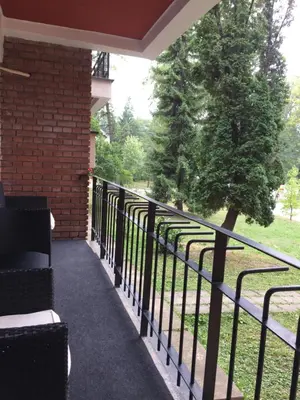 a balcony with a fence and a tree at Apartment Aloha in Vrnjačka Banja