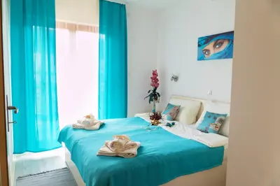 a bedroom with a blue bed with towels on it at Apartmani Maja Sokobanja in Soko Banja