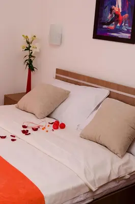 a bed with some roses and glasses on it at Apartmani Maja Sokobanja in Soko Banja
