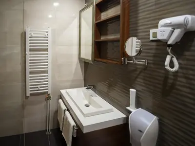 a bathroom with a sink and a toilet and a mirror at Hotel Ideo Lux in Niš