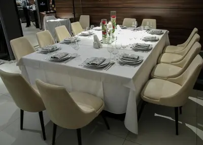 a white table with chairs and plates and wine glasses at Hotel Ideo Lux in Niš