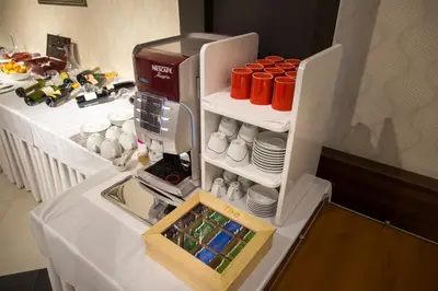 a refrigerator filled with cups and plates on a table at Hotel Ideo Lux in Niš