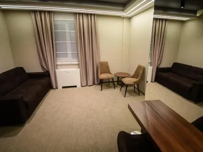 a living room with a couch and a table and chairs at Hotel Ideo Lux in Niš