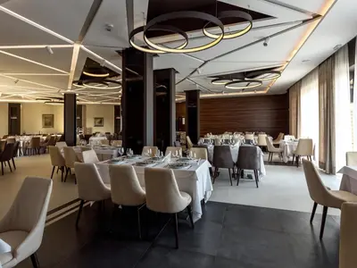 a dining room with white tables and chairs at Hotel Ideo Lux in Niš