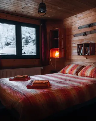 a bedroom with a bed with two towels on it at Apartman Pustolov - Stara planina in Crni Vrh