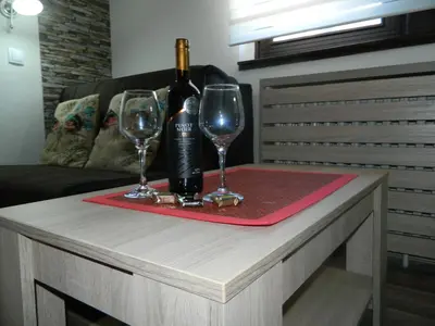 a table with two wine glasses and a bottle of wine at Apartment Sofi Yeti in Kopaonik