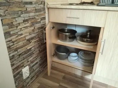 a kitchen cabinet with pots and pans and plates at Apartment Sofi Yeti in Kopaonik