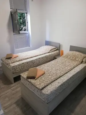 two twin beds in a room with a window at Athos Apartments in Niš