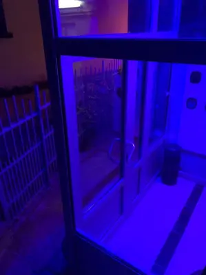 a room with a blue light on a glass door at Athos Apartments in Niš