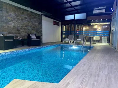 a large swimming pool with blue water in a building at Exclusive Spot FREE parking in Niš