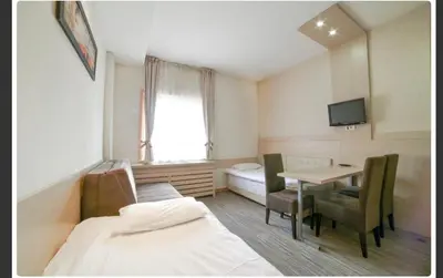 a room with a table and a bed and a table and chairs at Apartments Konaci Centar in Kopaonik