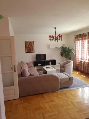a living room with a couch and a television at Poseidon Apartment in Niš