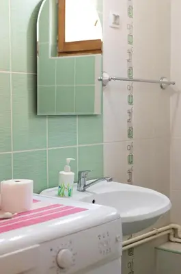 a bathroom with a sink and a toilet and a mirror at Poseidon Apartment in Niš