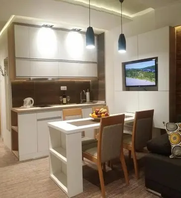 a kitchen with a table and chairs and a kitchen with a tv at Apartment Dream Konaci in Kopaonik