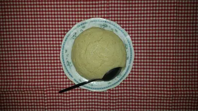 a bowl of food on a table with a spoon at Guest House Lisinski Raj in Despotovac