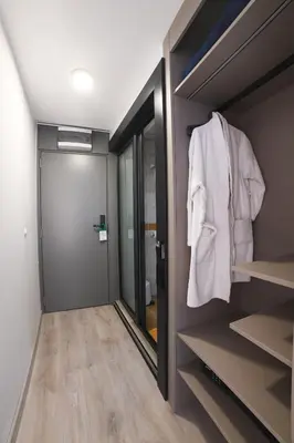 a walk in closet with a mirror and a robe at Medical and Spa Centre Merkur in Vrnjačka Banja