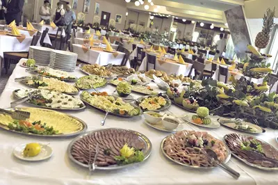 a table with many plates of food on it at Medical and Spa Centre Merkur in Vrnjačka Banja