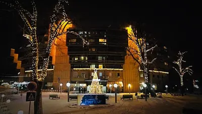 a building with a christmas tree in front of it at Medical and Spa Centre Merkur in Vrnjačka Banja