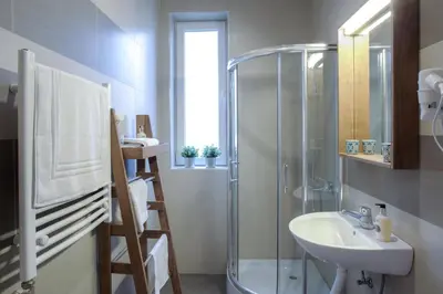 a bathroom with a glass shower and a sink at Brzeće Center Apartments in Kopaonik