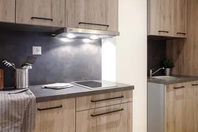 a kitchen with a sink and a stove top oven at Brzeće Center Apartments in Kopaonik