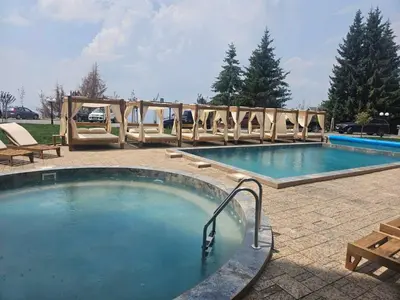 a large swimming pool with a wooden fence around it at Marrilux apartments Residence Hill in Kopaonik