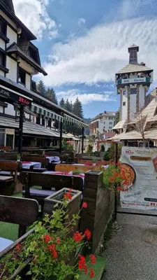 a patio with tables and flowers and a building at Marrilux apartments Residence Hill in Kopaonik