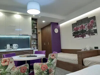 a room with a bed and a table and chairs at Select Lux Apartments Konaci Kopaonik in Kopaonik