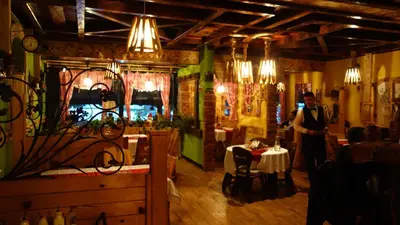 a man is standing in a restaurant with a table at Select Lux Apartments Konaci Kopaonik in Kopaonik