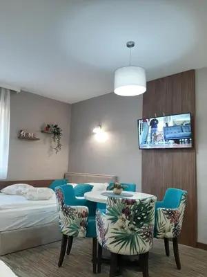 a room with a bed and a table and chairs at Select Lux Apartments Konaci Kopaonik in Kopaonik