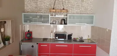 a small kitchen with red cabinets and a sink at Nice apartment in Niš