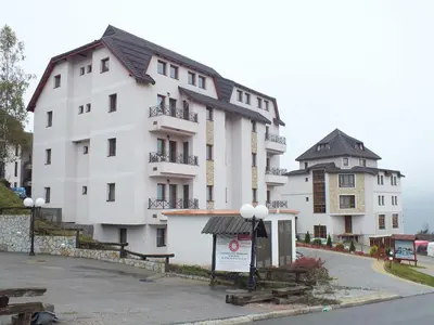 a large white building with a sign in front of it at Apartman FILIPOVIC Milmari D in Kopaonik