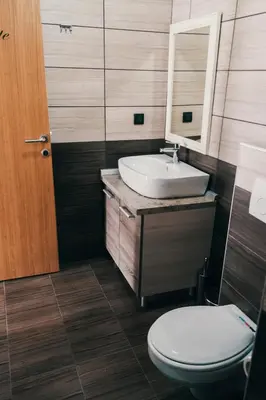 a bathroom with a sink and a toilet and a mirror at Apartman FILIPOVIC Milmari D in Kopaonik