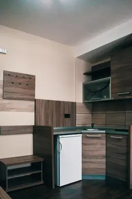 a kitchen with wooden cabinets and a white refrigerator at Apartman FILIPOVIC Milmari D in Kopaonik