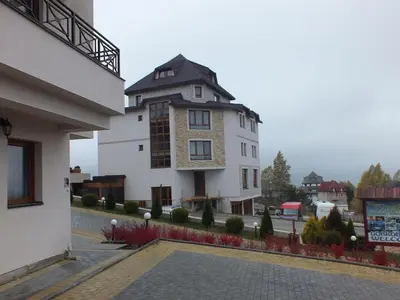 a large white building with a black roof at Apartman FILIPOVIC Milmari D in Kopaonik