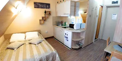 a small kitchen with a bed and a microwave at Elite Apartment Konaci in Kopaonik