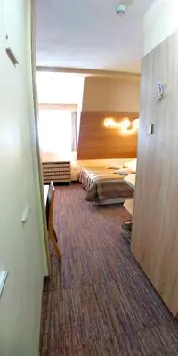 a room with two beds and a room with a hallway at Elite Apartment Konaci in Kopaonik