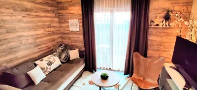a living room with a couch and a table at Apartment F10 Milmari Resort in Kopaonik