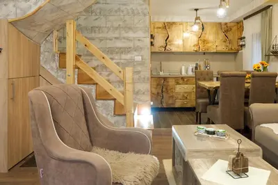 a living room with two chairs and a table at Villa Zagorka and mountain houses A, M, D in Kopaonik