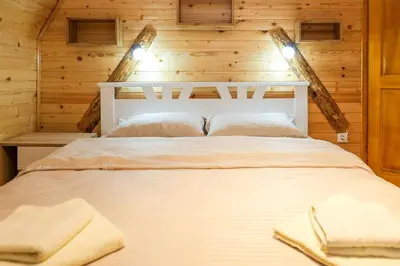 a bedroom with a bed in a log cabin at Villa Zagorka and mountain houses A, M, D in Kopaonik