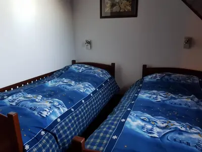 a bedroom with two beds with blue sheets at Planinski Biser in Kopaonik