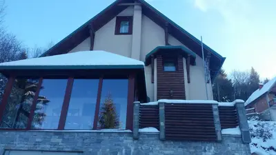 a house with a bench in the snow at Planinski Biser in Kopaonik