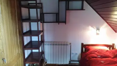 a bedroom with a staircase leading to a bed at Planinski Biser in Kopaonik