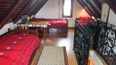 a living room with two beds and a staircase at Planinski Biser in Kopaonik