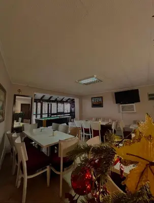 a dining room with tables and chairs and a television at Stara Bačija in Kopaonik