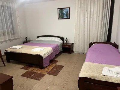 two beds in a room with purple sheets at Stara Bačija in Kopaonik