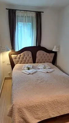 a bedroom with a bed with two towels and a window at Kamena Kuca Lux Apartment in Kopaonik