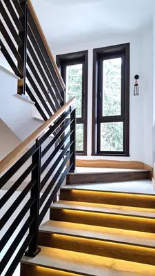 a staircase in a house with wooden steps and windows at Kamena Kuca Lux Apartment in Kopaonik