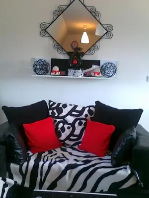 a couch with red and black pillows in a living room at Apartman ČAR 19 in Kopaonik