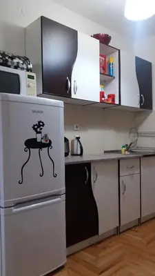 a kitchen with a table on the door of a refrigerator at Apartman ČAR 19 in Kopaonik