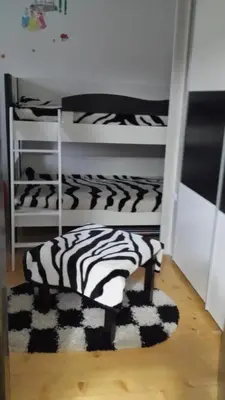 a room with two bunk beds and a zebra rug at Apartman ČAR 19 in Kopaonik